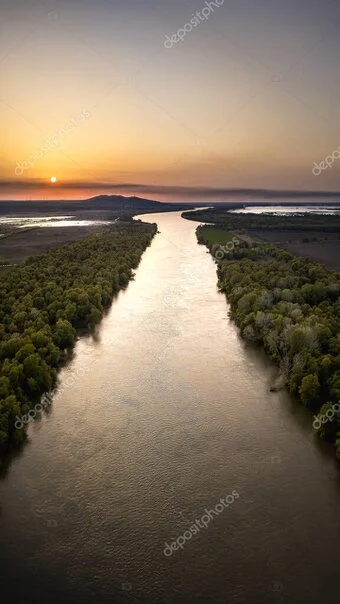Soft sunrise light over a flooded Botswana landscape with scattered trees