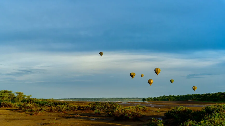 Hot air baloon flying over the ndutu lake during the calving season of the great migration