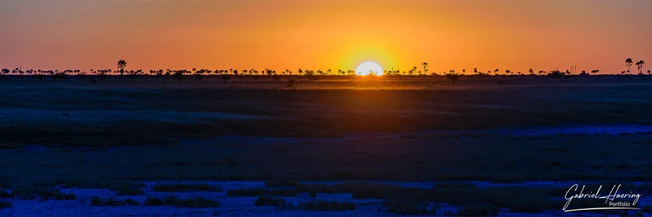 Sunset over the flat horizon of the Makgadikgadi Pans in Botswana
