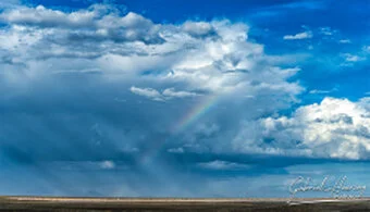 Storm clouds and rainbow over Lake Natron, atmospheric landscape photography in Tanzania