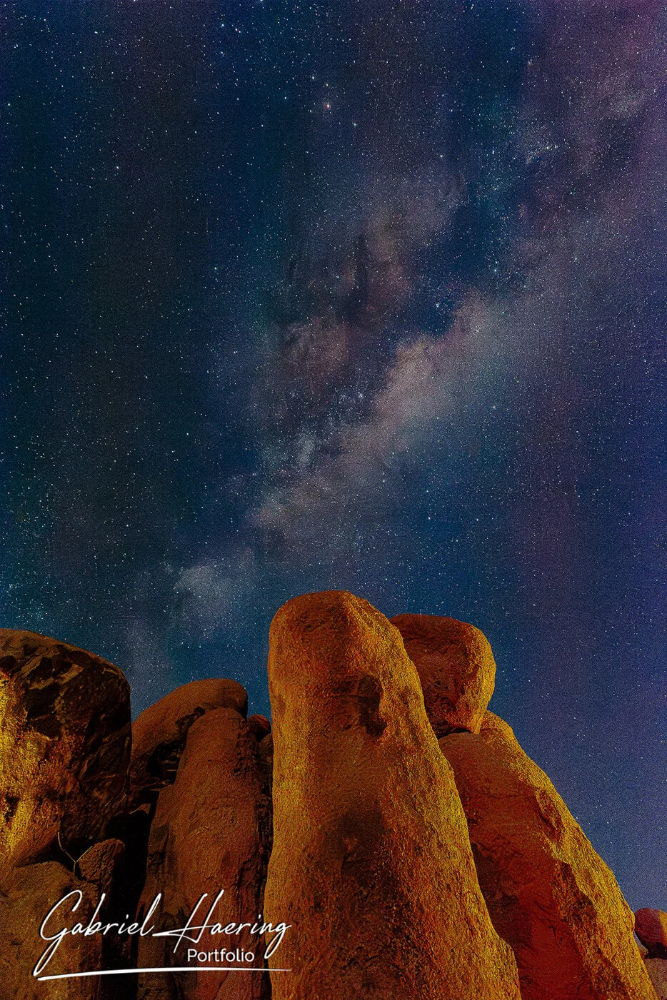 Milky Way rising above illuminated granite rocks in the night sky of Damaraland, Namibia